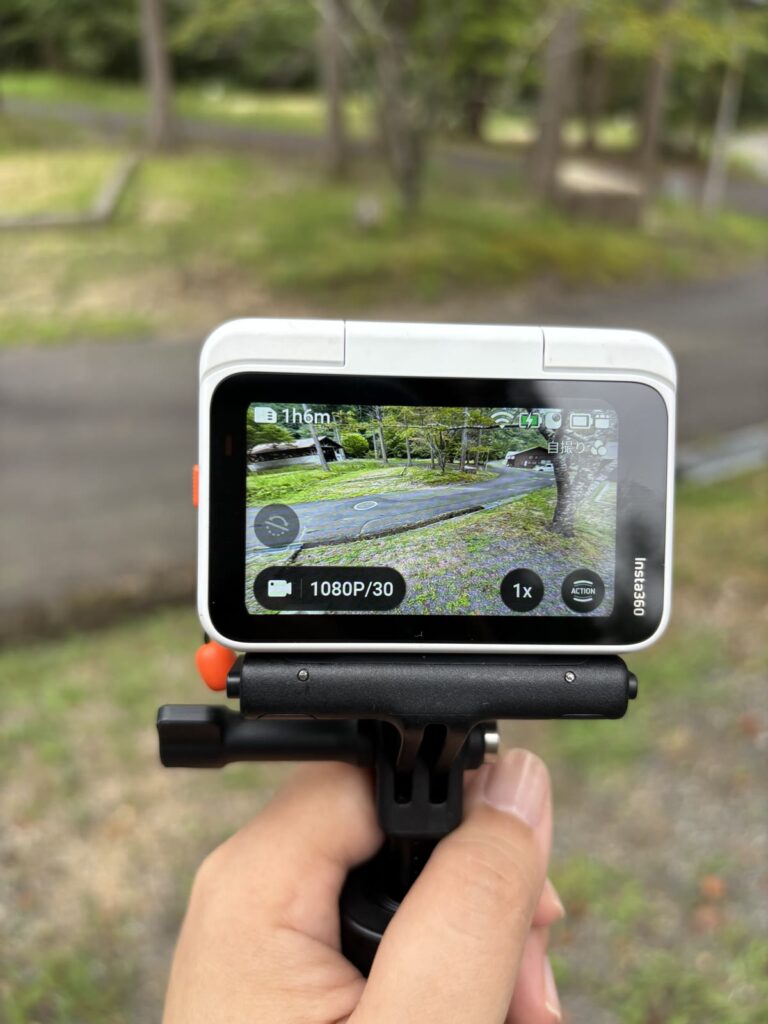 アクションポッドの画面で撮影範囲を確認しながらInsta360 GO Ultraを構える様子