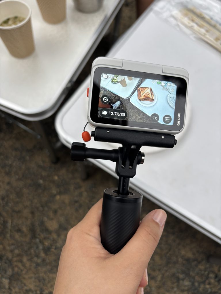 キャンプ場で自撮り棒に付けたInsta360 GO Ultraを持って撮影する様子