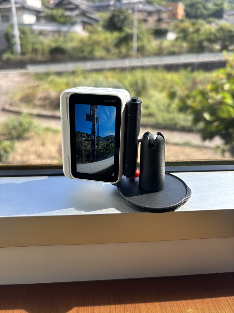窓際のマウントに付けたInsta360 GO Ultraとアクションポッド